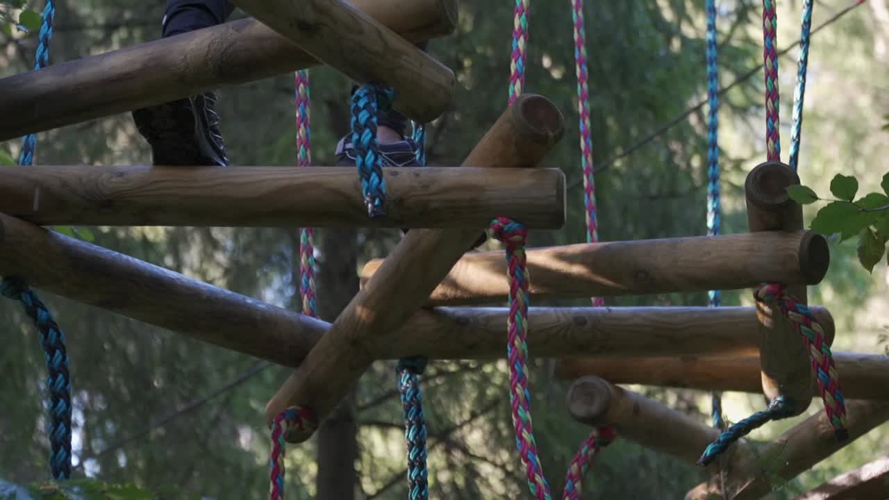 A man is carefully climbing on the wooden
