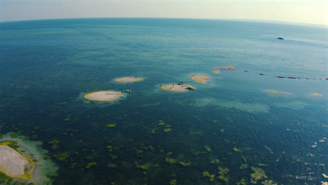 Drone-Volando-Sobre-Islas-De-Arena-En-Medio-Del-Océano-En-El-Soleado-Día-De-Verano