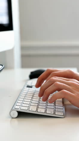 close-up of hands typing on a computer keyboard