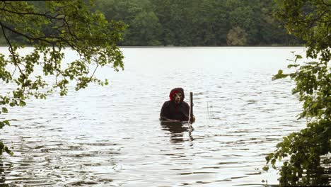 parca con guadaña sumergida en el agua del río