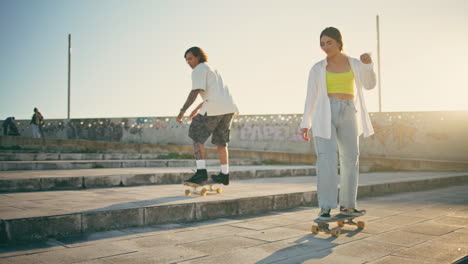 positive sweethearts practicing skate ride sunbeams stadium. girlfriend clapping