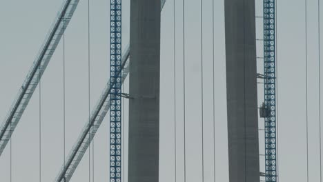 static close up shot of an elevator going up to the top of a suspended bridge under construction, big structure