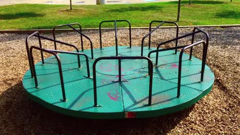 wide view of empty children's merry-go-round turning in a park