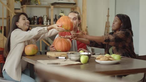 young ladies exchange their pumpkins and start to draw it