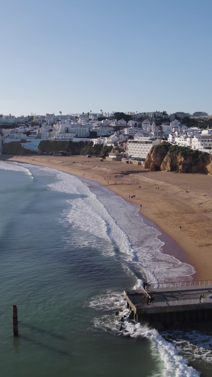 Ripresa aerea verticale in allontanamento dalla spiaggia di Albufeira, una famosa costa sabbiosa in Algarve, Portogallo.