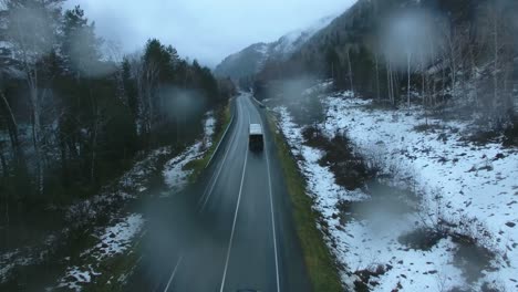 mountain road in winter with rain
