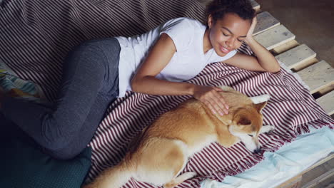 woman and her dog relaxing on bed