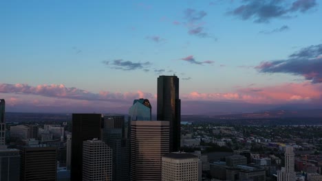 panning aerial of seattle's downtown skyline amidst a beautiful pink sunset