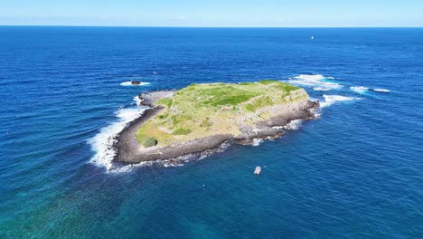 island surrounded by ocean waves and rocky formations