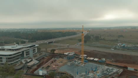 Antena-De-Drones-De-Grúa-De-Construcción-En-Un-Sitio-De-Construcción-De-Bloques-De-Oficinas-Girando