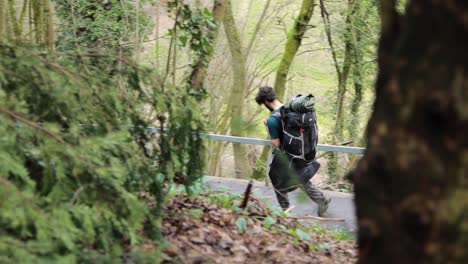 backpacker guy trekking alone on hiking path outdoors