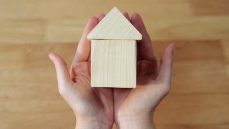 mano de una mujer sosteniendo una casa modelo