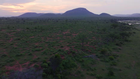 drone entrada kruger parque nacional aero cinematográfico impresionante arbusto naranja rosa rojo puesta de sol cerca de la puerta sur pájaros lluviosa primavera verde exuberante impresionante paisaje montañoso movimiento hacia adelante