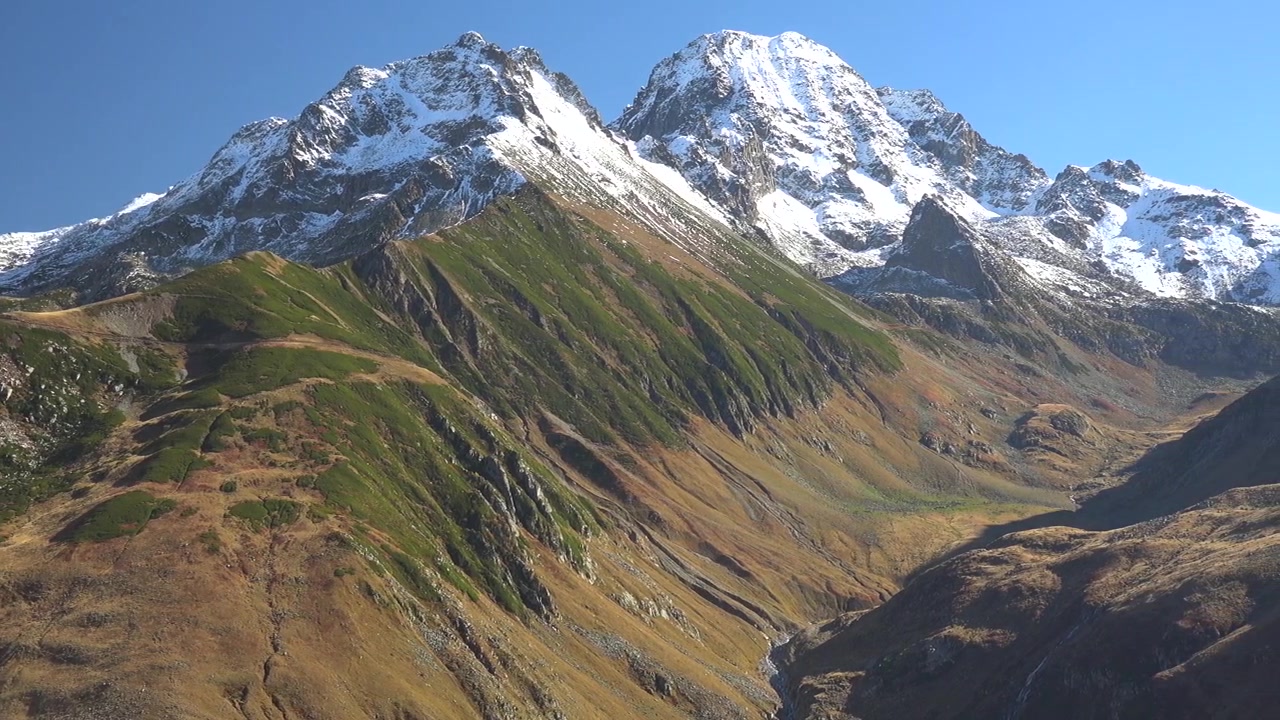 Panoramic View of Snow-Capped Mountain Peaks and Alpine Valley