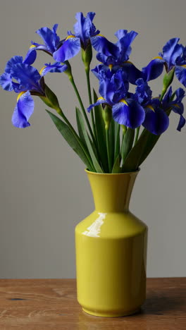 blue irises in a yellow vase