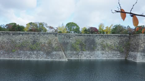 osaka castle moat walls, pan across ancient tall defense structure, japan