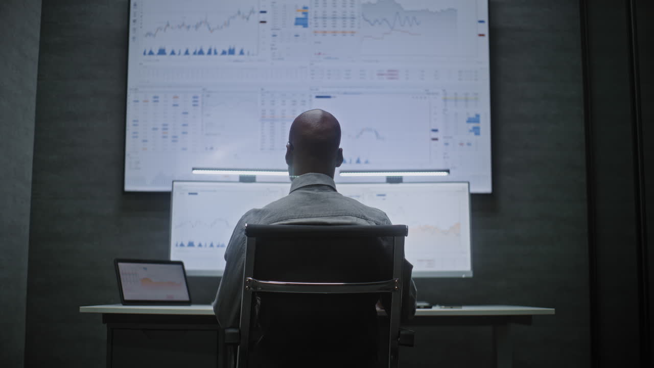 Stock Exchange Broker Monitoring Real-Time Stocks, Exchange Market Charts on Computer with Multi-Monitor Desktop Setup, Talking on Phone. African American Investment Agent in Office. Vertical Shot.
