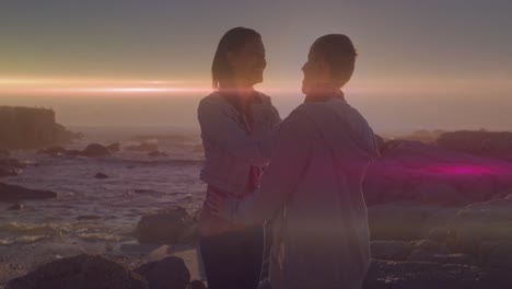 animación de puntos de luz sobre una pareja caucásica en la playa