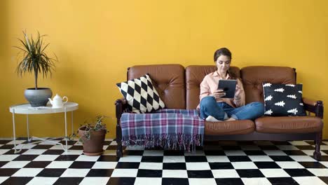 woman relaxing on couch with tablet