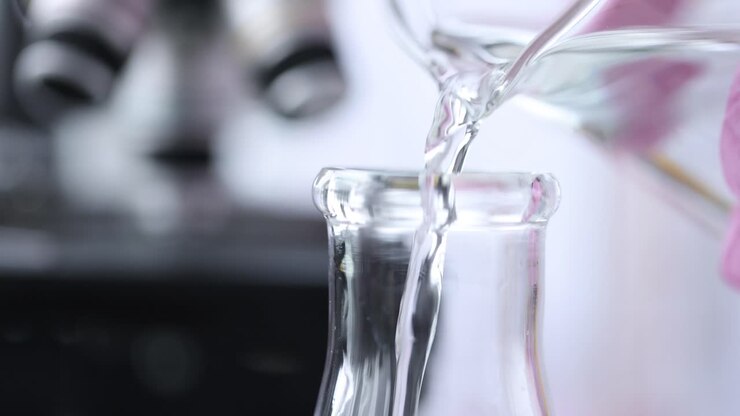 Liquid being poured into a beaker in a lab