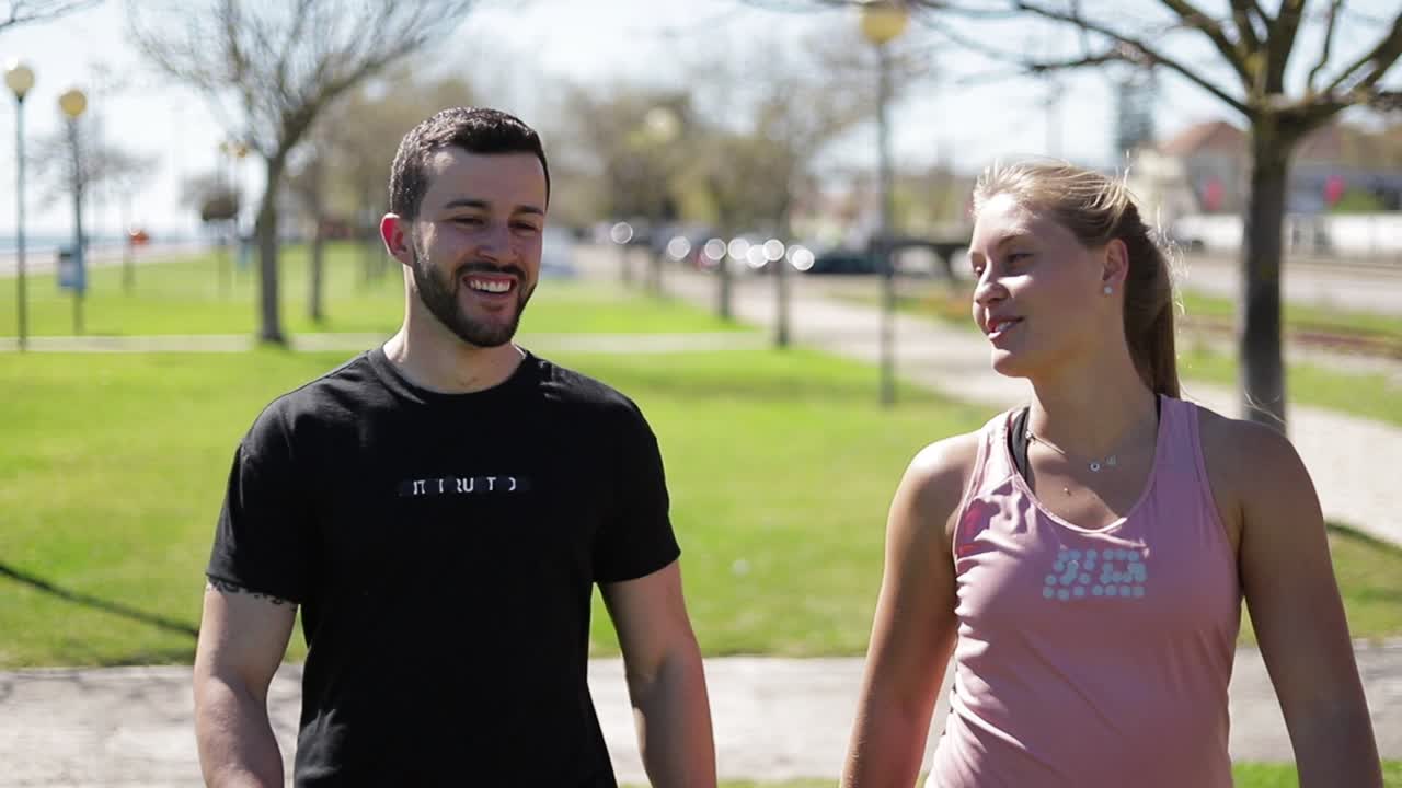 jóvenes sonrientes hablando mientras descansan después del entrenamiento.