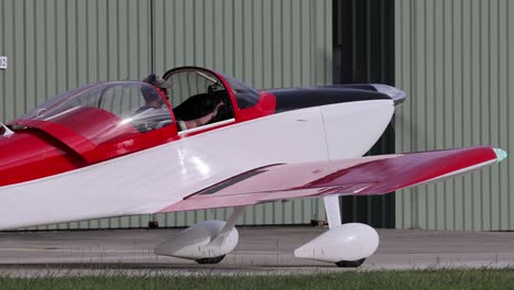 light aircraft moves past a green hangar door