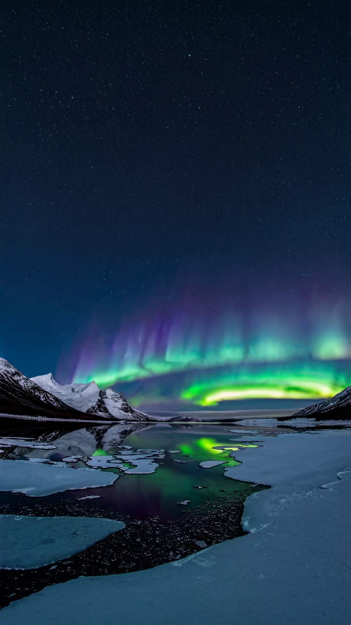A stunning wide-angle shot captures the vibrant Northern Lights over icy landscapes