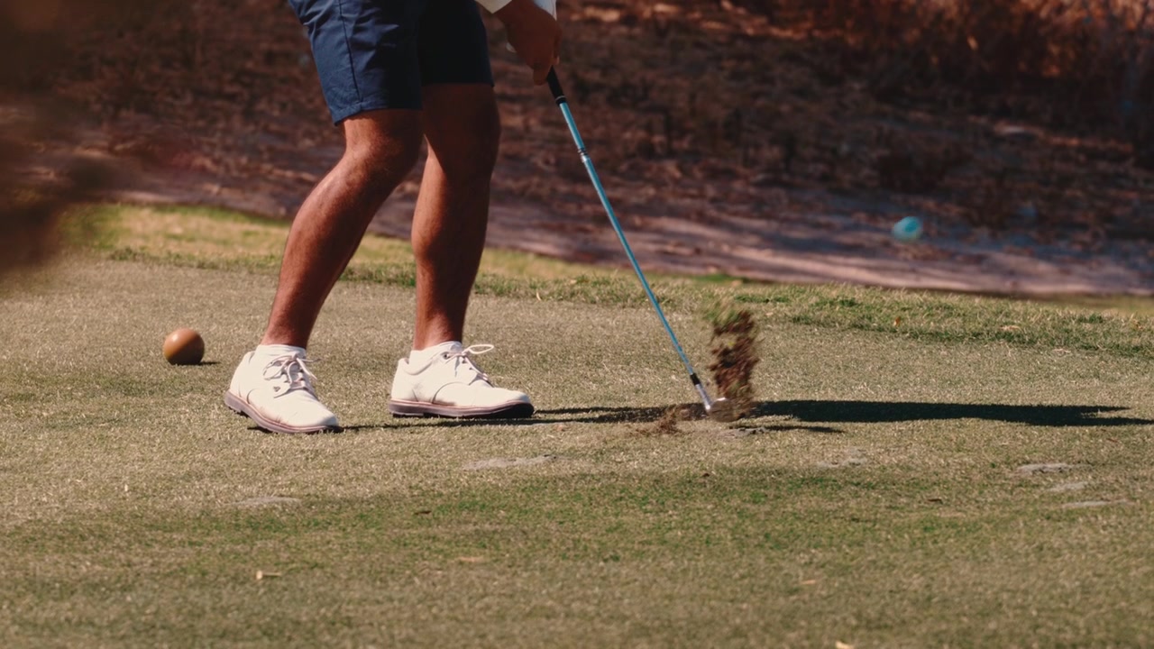 Close on a golfer's legs rotating and shifting weight through a tee shot on a warm desert course, captured in 4k 800fps slow motion, useful for swing tips and sports ads.