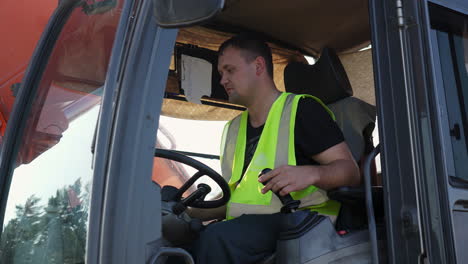 a man operating heavy machinery in a high-visibility vest