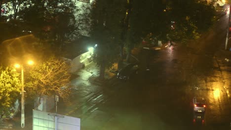 vista nocturna de la ciudad después de la lluvia con luces borrosas farolas y coches raros que pasan