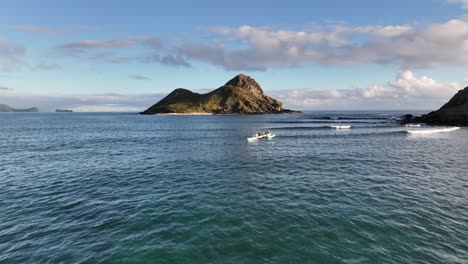 aerial pan up of mokulua islands in lanikai hawaii with paddlers in hawaii canoes and beach views