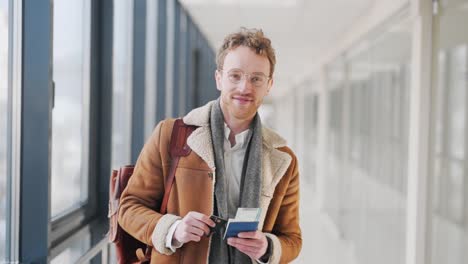 cute young man shows documents with a ticket and a plastic card