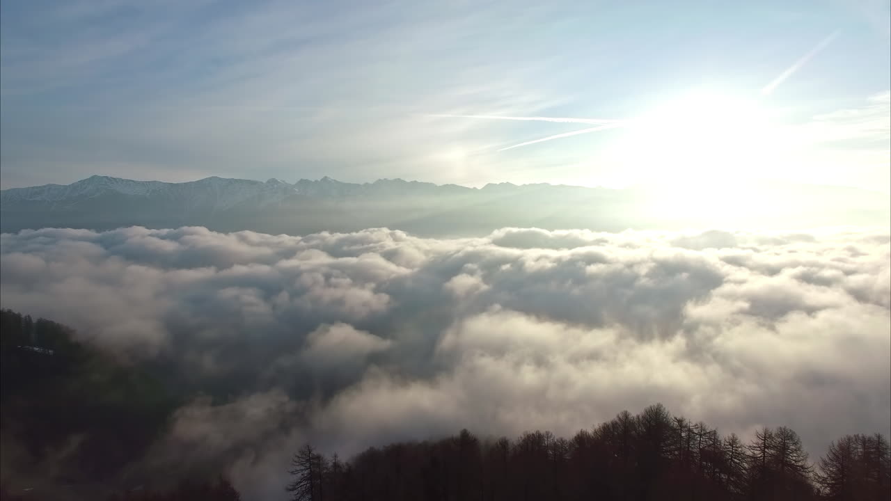 밝은 태양을 배경으로 구름 위로 날아가는 드론