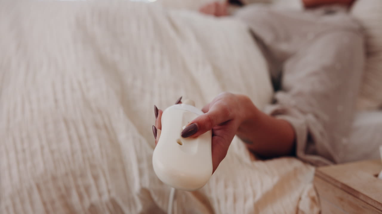 mujer relajándose en la cama con el control remoto