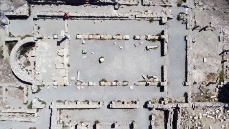aerial drone shot zooming out of a greek temple revealing the entire site by the sea