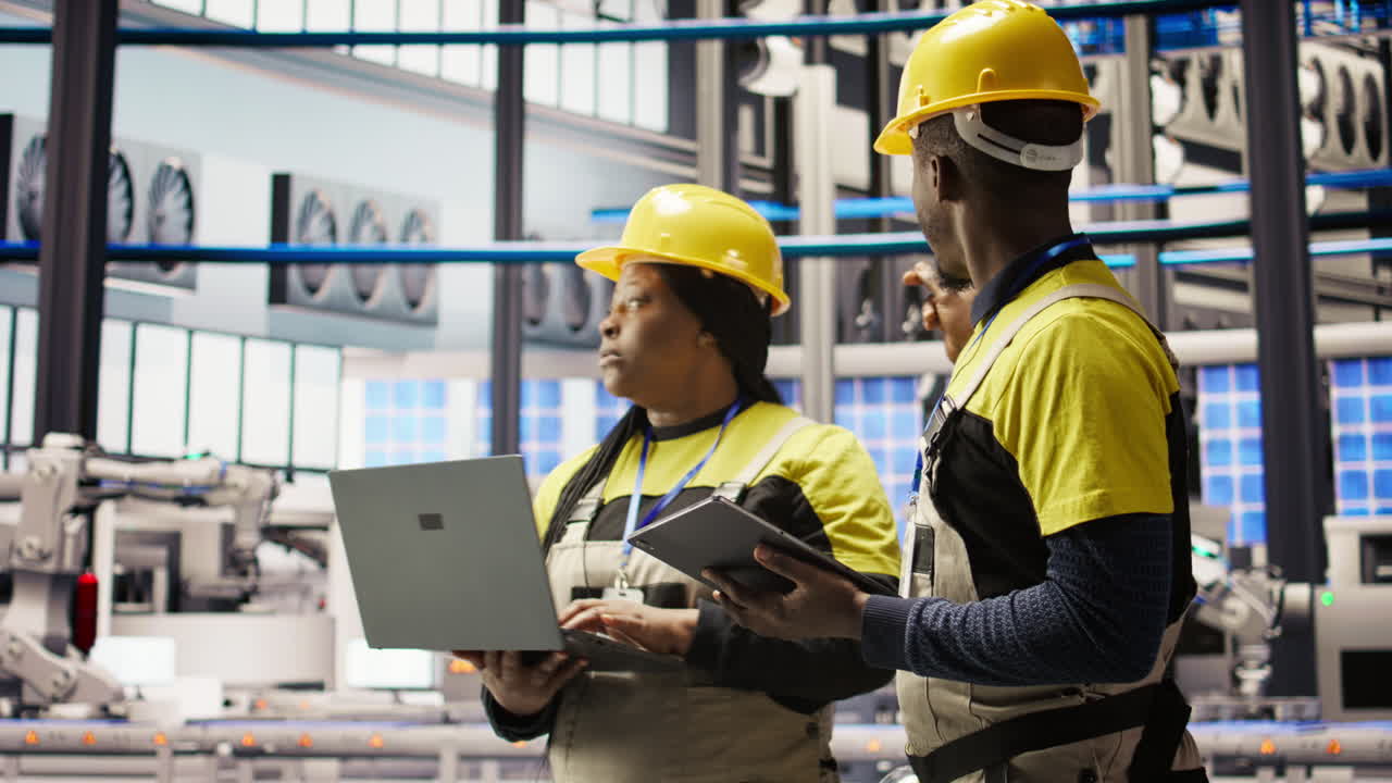 Vertical video Solar panels factory engineering team analyzes performance data on laptop