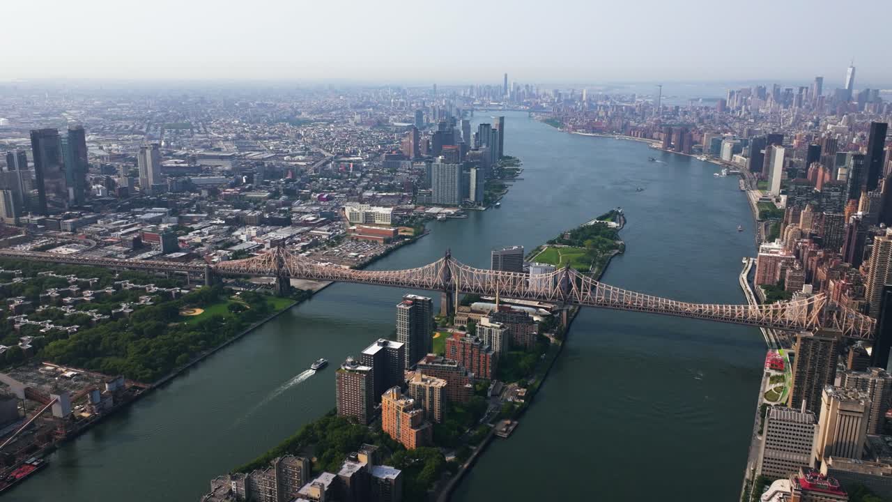 Aerial view of a ferry driving under the Queensboro Bridge, on East river in NYC