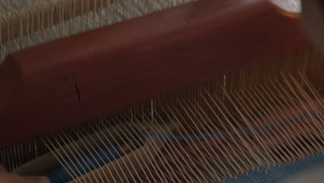 weaver makes fabric in ethnic loom