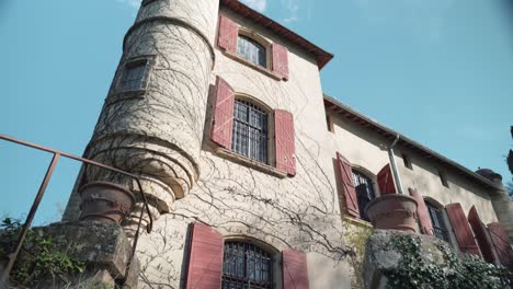 low-angle shot of a southern french castle with stairs, as creepy climbing plants on the tower evoke a horror film