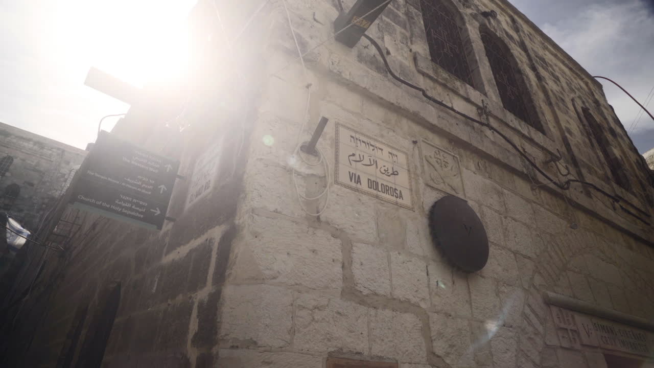 Pivoting shot of the Via Dolorosa street sign marking where Jesus Christ carried the cross in Jerusalem, Israel.