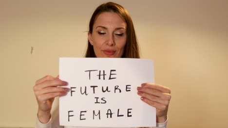 enthusiastic woman holding a sign that says 'the future is female', empowering message