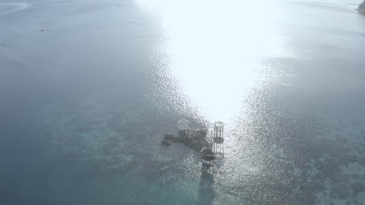 필리핀 표면에 밝은 햇빛이 반사되는 맑은 물 한가운데 서 있는 아름다운 럭셔리 코티지 리조트