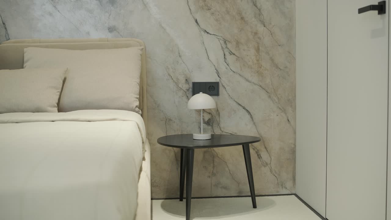 interior de dormitorio moderno con mesita de noche y pared de acento de mármol