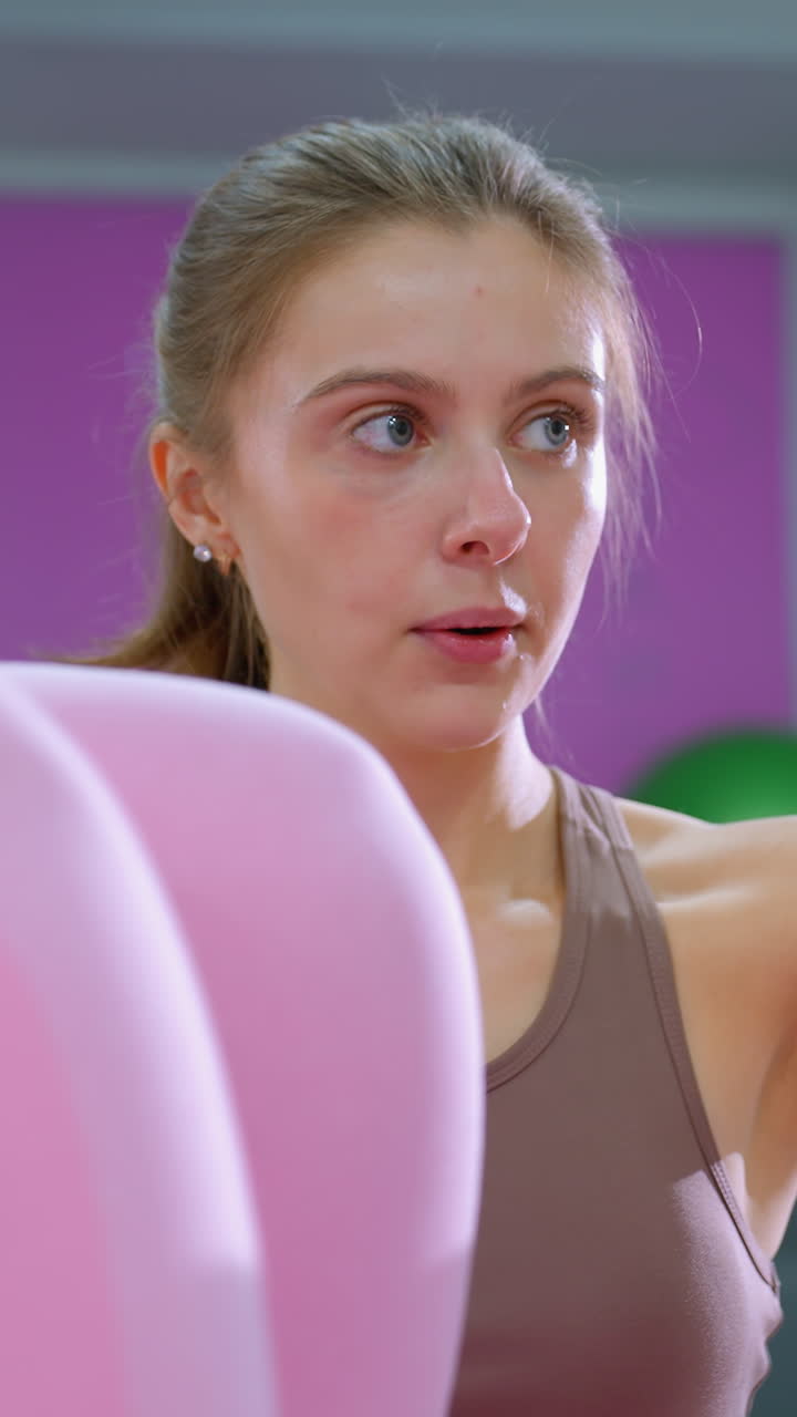 entrenador de fitness centrado supervisa la sesión de entrenamiento abdominal con la dama de rosa, primer plano en el entrenamiento en el entorno del gimnasio, motivación de fitness y orientación