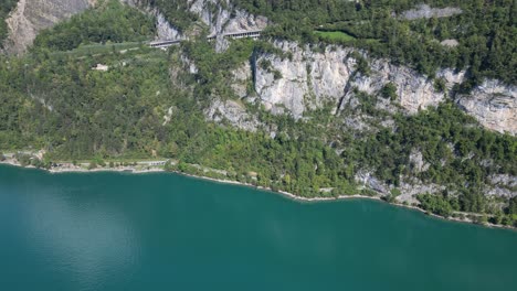 a bird's-eye view of the lush green mountain hills surrounding the clear turquoise waters of walensee in switzerland