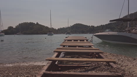 wooden gang plank on beach in nydri port, lefkada greece