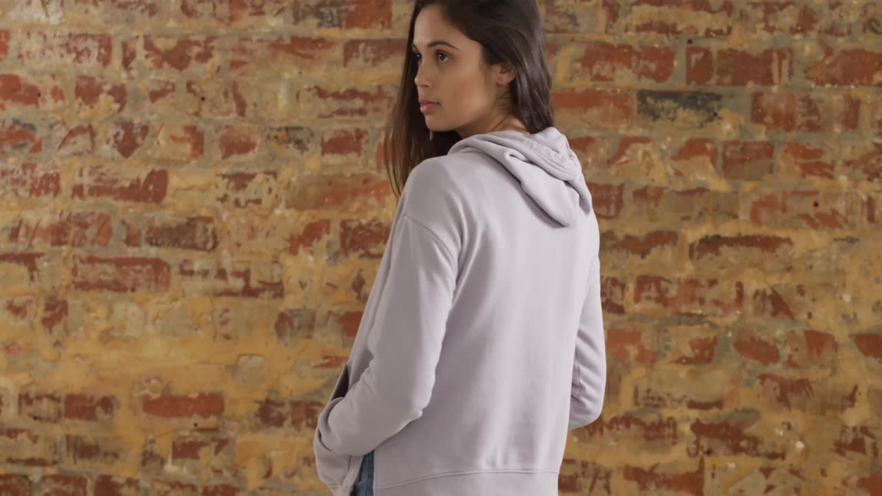 la espalda de una mujer caucásica en una pared de ladrillo