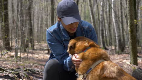 chica bonita amando a su perro en el medio del bosque en un sendero de senderismo