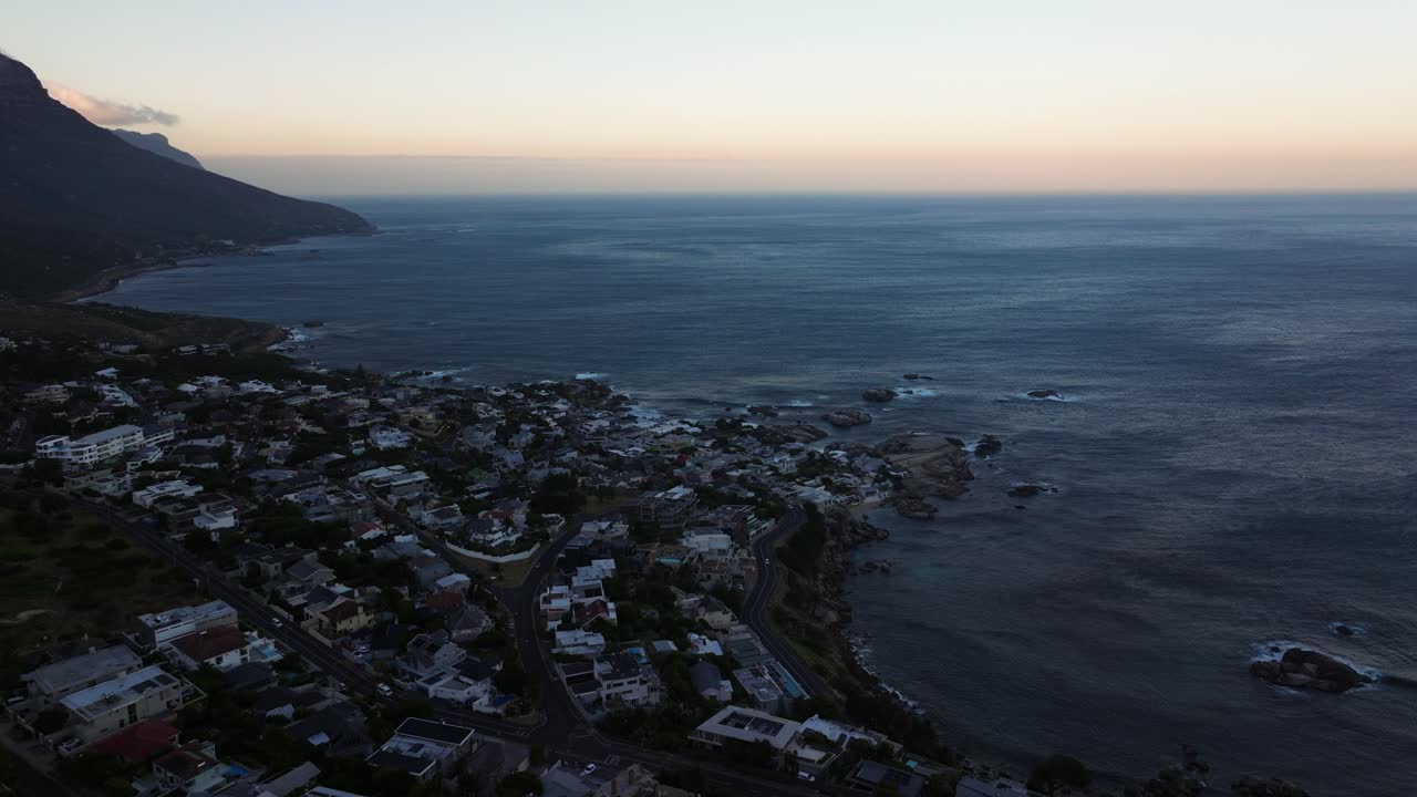 케이프타운, 남아프리카 공화국에서 해가 뜨는 동안 캠프스 베이 바위 해안에서 놀라운 드론