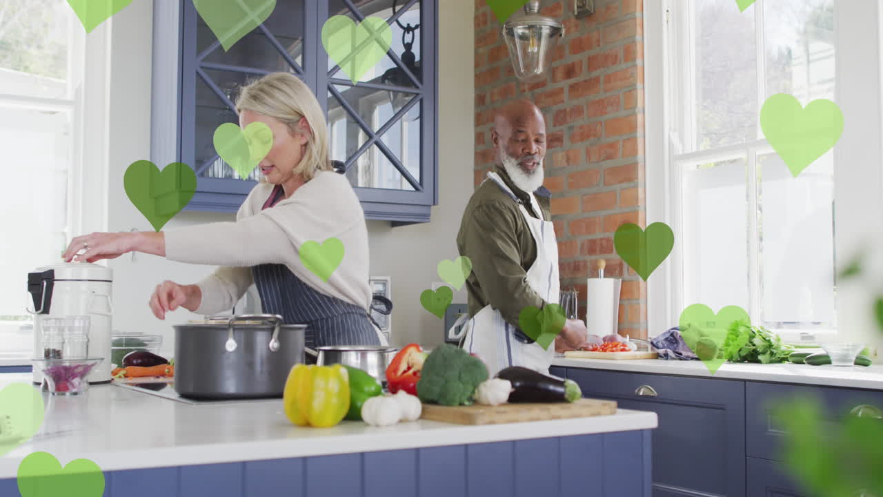 Animação de ícones de coração sobre casal diverso cozinhando juntos